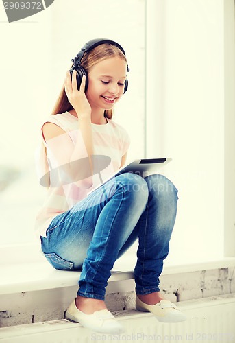 Image of girl with tablet pc and headphones at home