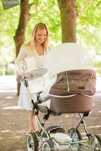 Image of happy mother with stroller in park