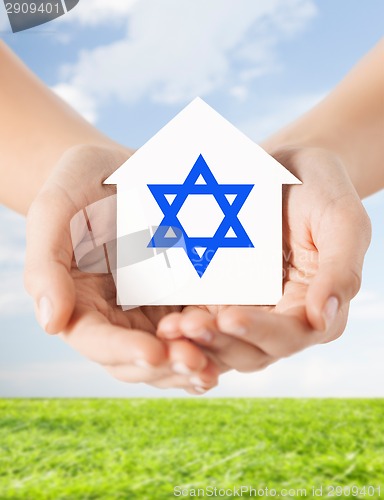 Image of close up of hands holding house with star of david