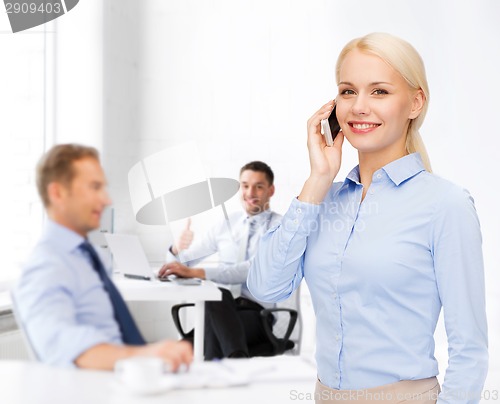 Image of young smiling businesswoman with smartphone