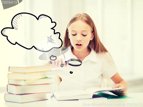 Image of girl reading book with magnifier at school