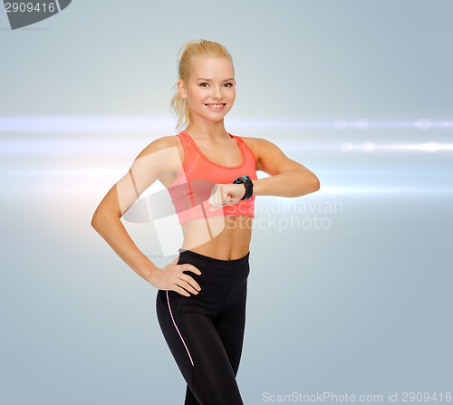 Image of smiling woman with heart rate monitor on hand