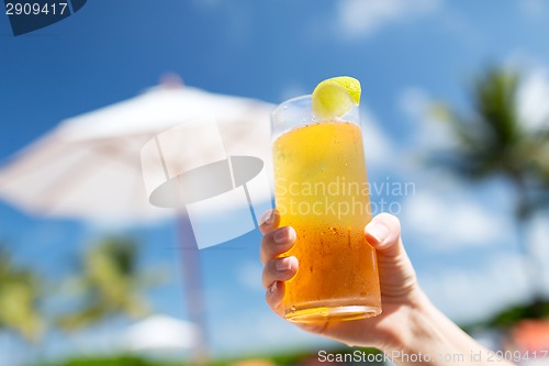 Image of close-up of hand holding glass with cocktail
