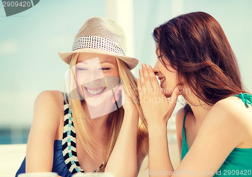 Image of girls gossiping in cafe on the beach