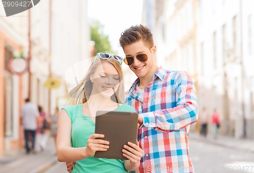 Image of smiling couple with tablet pc in city