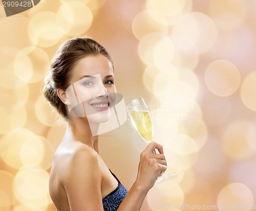 Image of smiling woman holding glass of sparkling wine