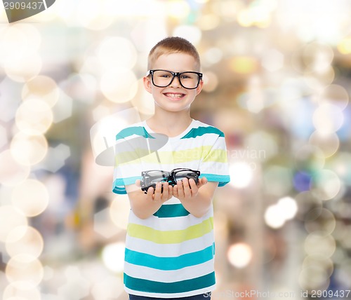 Image of smiling boy in eyeglasses holding spectacles