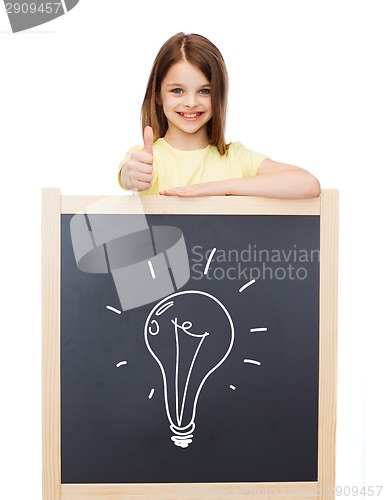Image of smiling girl with blackboard showing thumbs up
