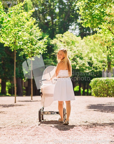 Image of happy mother with stroller in park