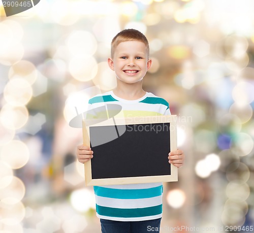 Image of smiling little boy holding blank black chalkboard