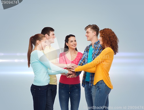 Image of smiling teenagers with hands on top of each other