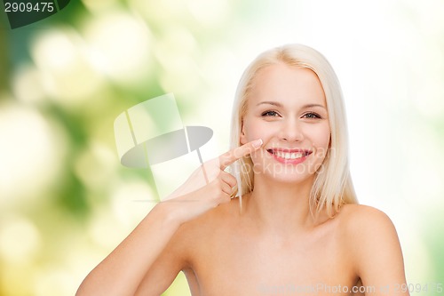 Image of smiling young woman pointing to her nose