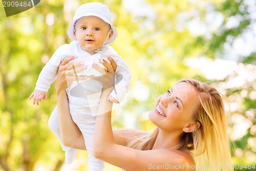 Image of happy mother with little baby in park