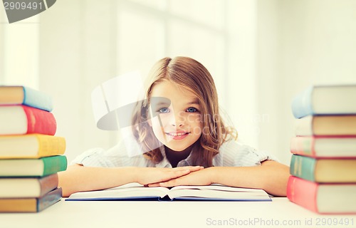 Image of smiling little student girl with many books
