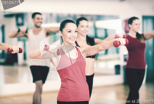 Image of group of smiling people working out with dumbbells