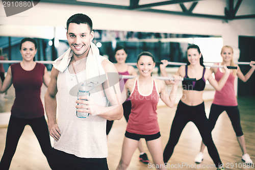 Image of smiling trainer in front of group of people