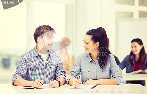 Image of two teenagers with notebooks at school