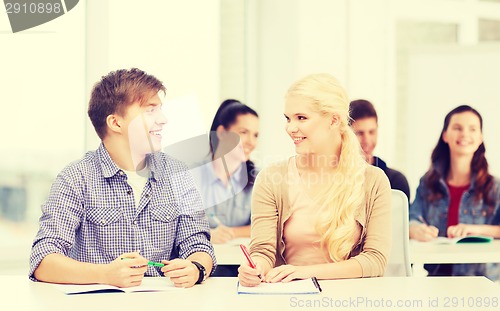 Image of two teenagers with notebooks at school