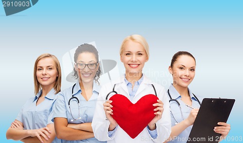 Image of smiling female doctor and nurses with red heart