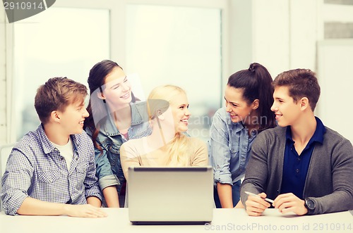 Image of smiling students with laptop at school