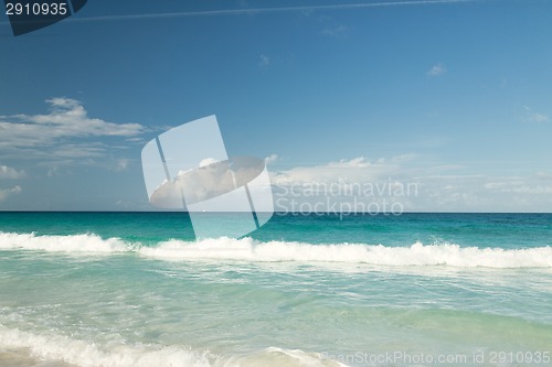Image of blue sea or ocean, white sand and sky with clouds