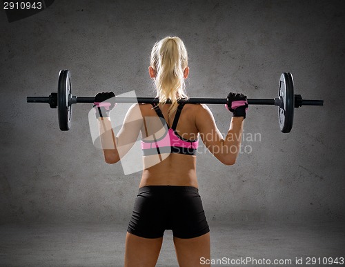 Image of sporty woman exercising with barbell from back