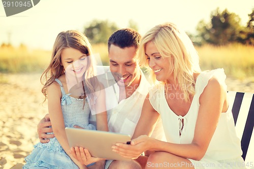 Image of smiling family at beach with tablet pc computer