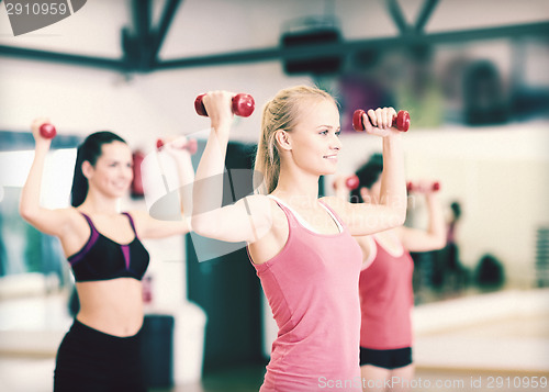 Image of group of smiling women working out with dumbbells