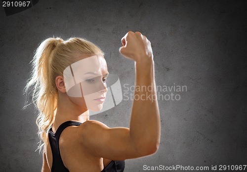 Image of sporty woman from the back flexing her biceps
