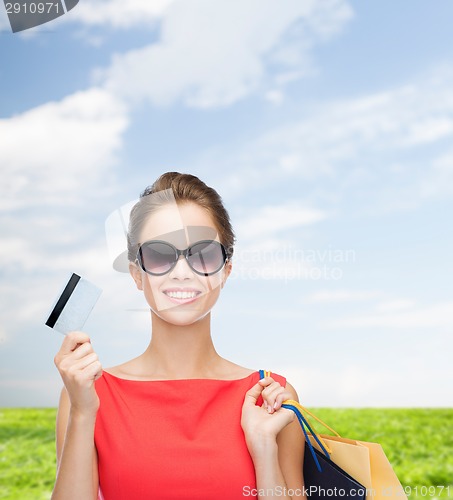Image of smiling woman with shopping bags and plastic card