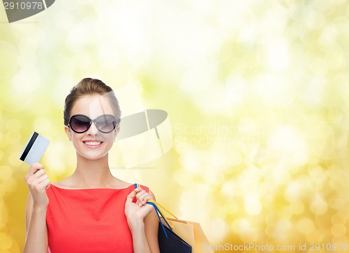 Image of smiling woman with shopping bags and plastic card