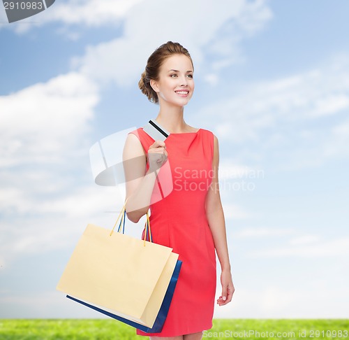 Image of smiling woman with shopping bags and plastic card