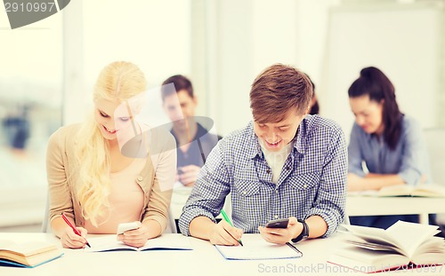 Image of students looking into smartphone at school