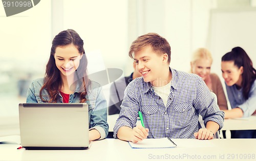 Image of students with laptop and notebooks at school