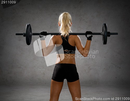 Image of sporty woman exercising with barbell from back