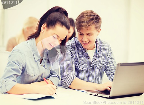 Image of students with laptop and notebooks at school