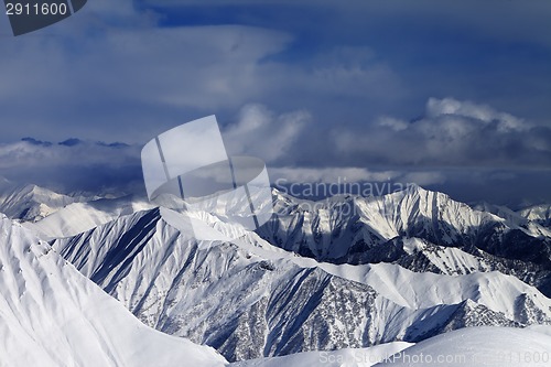 Image of Sunlight snowy mountains and storm clouds