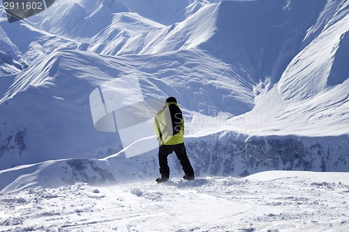 Image of Snowboarder on top of off-piste slope at windy day