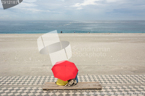 Image of Couple on beach under umbrella