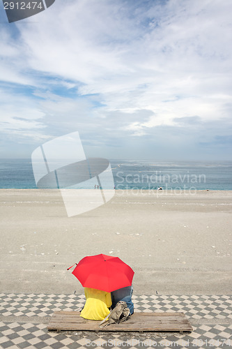 Image of Couple on beach under umbrella