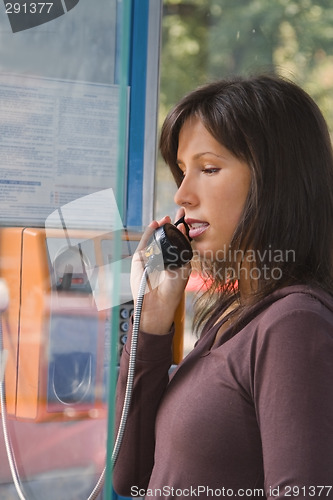 Image of Woman in public phone cabin