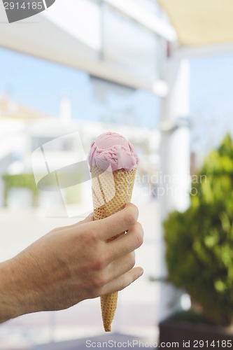 Image of Hand holding pink ice-cream