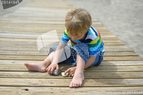 Image of Boy playing on a wooden walkway on the beach