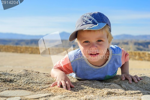 Image of Small boy laying down on the rock