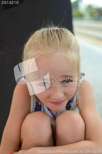 Image of Little girl hugging her knees