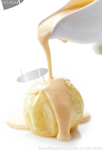 Image of vanilla sauce pouring on baked apple