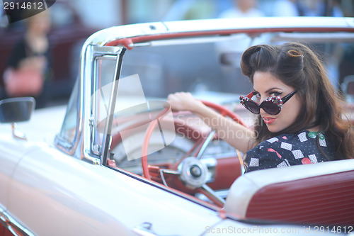 Image of Lovely Woman Posing and and Around a Vintage Car
