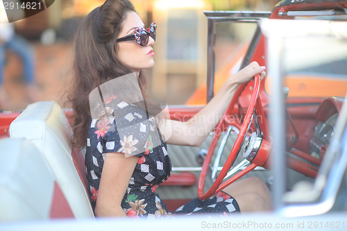 Image of Lovely Woman Posing and and Around a Vintage Car