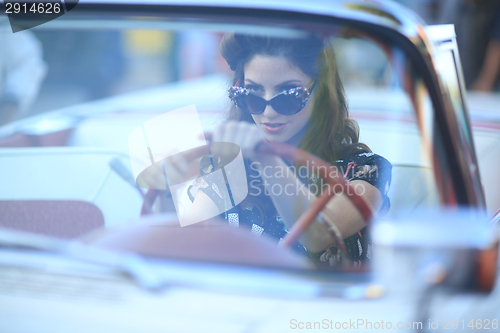 Image of Lovely Woman Posing and and Around a Vintage Car