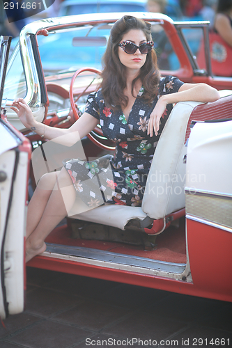 Image of Lovely Woman Posing and and Around a Vintage Car